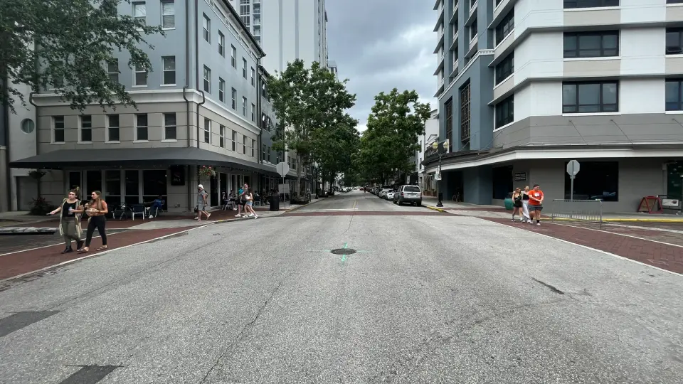 Buildings, sidewalk seating, and pedestrians along Central Boulevard in downtown Orlando.